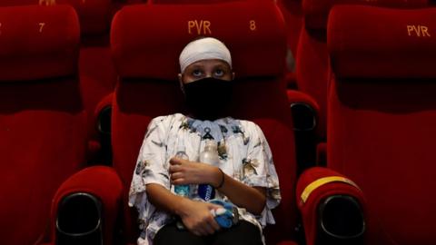 A person watching a movie in Delhi after cinemas reopen