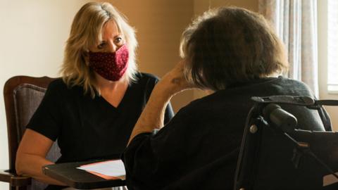 Stock image of a care worker with an elderly person in a wheelchair