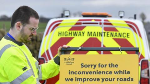 Highway maintenance with a road closure sign