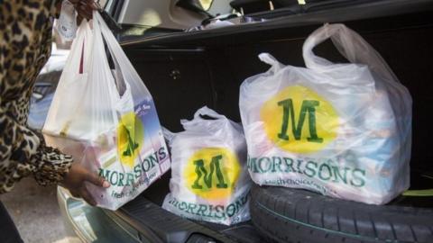 Woman loading Morrisons shopping into her car
