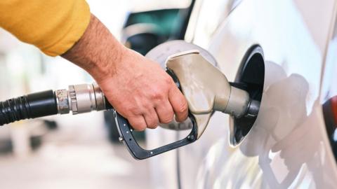 A person filling up their car wit petrol