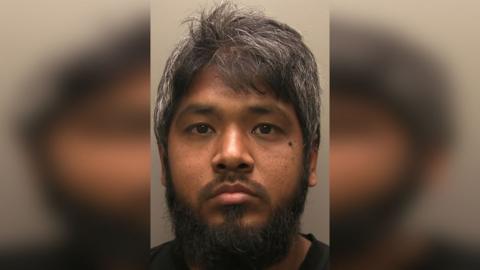 Custody picture of Tarequl Islam he has black hair and beard and is wearing a black t-shirt