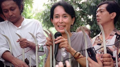 Myanmar pro-democracy leader and Nobel Peace laureate Aung San Suu Kyi (C) addresses 14 July 1995 hundreds of anxious Burmese supporters from the main gate of her family compound in Rangoon