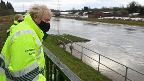 Boris Johnson talks with Environment Agency workers during a visit to a storm basin near the River Mersey