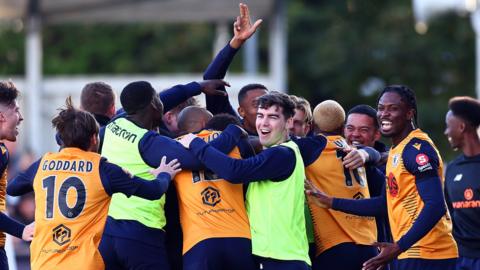 Slough Town FC celebrate after Scott Davies scored from a free kick during the Emirates FA Cup First Round match between Slough Town and Grimsby Town at Arbour Park on November 05, 2023 in Slough, England.