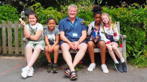 Teacher and children on a bench