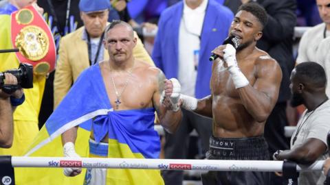 Oleksandr Usyk looks on as Anthony Joshua speaks