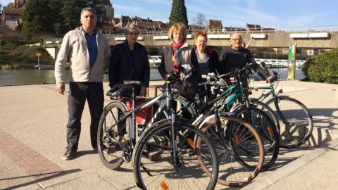 A group of cyclists by the canal in Dole