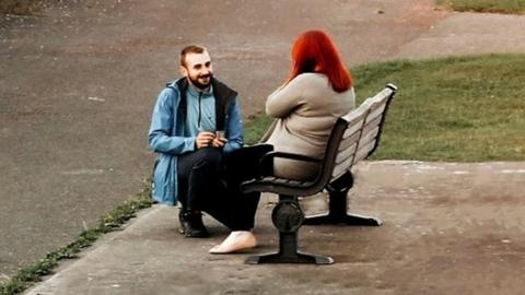 man proposing to woman on bench