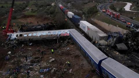 Train derailed with emergency workers standing nearby