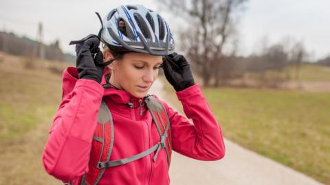 woman putting on bike helmet