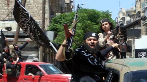 Fighters from Jabhat Fateh al-Sham (formerly al-Nusra Front) drive in the northern Syrian city of Aleppo while flying Islamist flags, in 2015