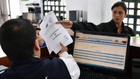 A Venezuelan migrant submits documents at the binational border attention centre (CEBAF) in Huaquillas, Southern Ecuador in the border with Peru on August 24, 2018.