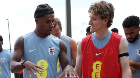 Marcus Rashford and Anthony Gordon of England interact as they walk out for a training session