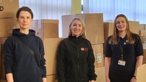 Essex Fire and Rescue team standing next to boxes filled with items to help refugees in Ukraine.