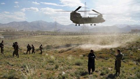 US military Chinook helicopter lands on a field