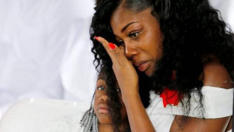 Myeshia Johnson sits with her daughter, Ah'Leeysa Johnson at a graveside service in Hollywood, Florida