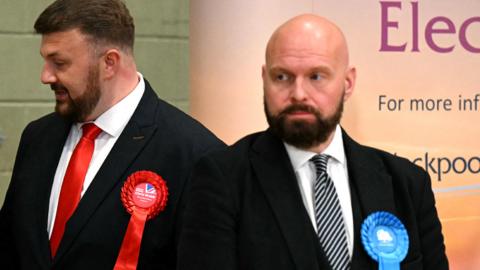 New Labour Party MP for Blackpool South, Chris Webb, and beaten Conservative candidate David Jones looks on at the count centre in Blackpool, north-west England on 3 May 2024, after the declaration for the Blackpool South by-election