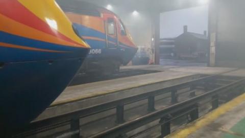 Train pulling into a foggy depot