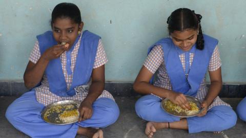 Students eat their mid-day meal during lunch break at a government high school on the outskirts of Hyderabad on 23 November 2021