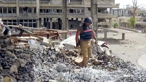 Mine clearance operative in rubble in Iraq