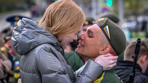 A Russian serviceman kisses his girlfriend