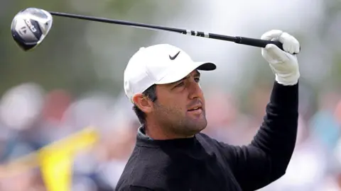 Scottie Scheffler holds his driver