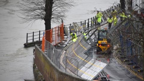 Environment Agency teams work on temporary flood barriers