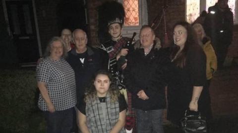 Tony Occleshaw with the piper and his family