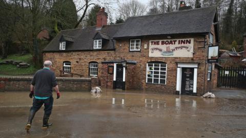A resident at the Boat Inn in Jackfield near Ironbridge after flood water has started to recede