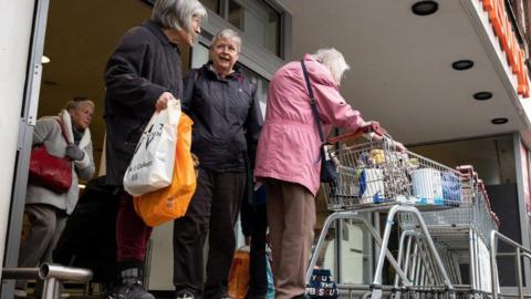 Elderly shoppers outside Sainsbury's