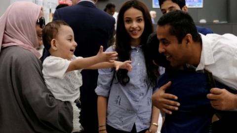 A family hug each other at Washington Dulles Airport on 26 June, 2017, after the U.S. Supreme Court granted parts of the Trump administration's emergency request to put its travel ban into effect