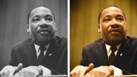 Dr. Martin Luther King leans forward over a podium