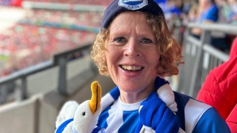 Monica Fletcher in white and blue at an Albion game