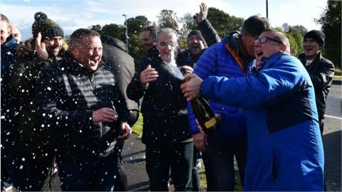 Wrightbus workers celebrate with champagne