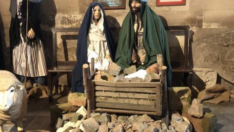 Crib scene surrounded by rubble