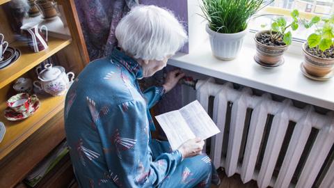 Woman holding bill by radiator