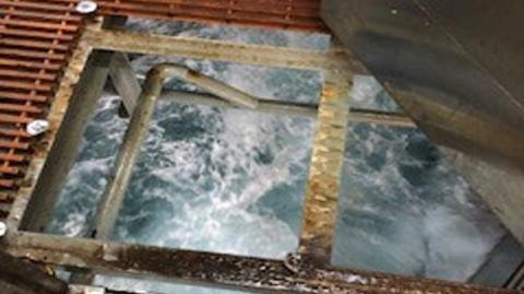 A gap in North Sea rig grating which shows the sea below.