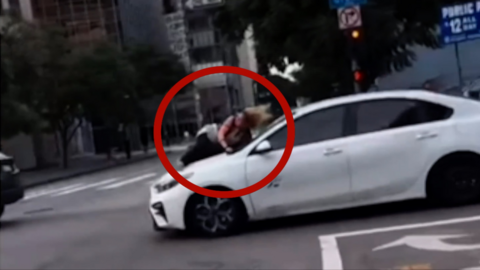 An image showing the woman clinging to the hood of a car in Los Angeles