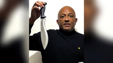 Man holds a machete knife