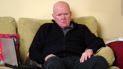 Phil Mitchell sitting on a sofa looking unhappy