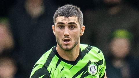 Jordan Moore-Taylor runs with the ball during a match for Forest Green