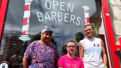Staff in front of Open Barbers window