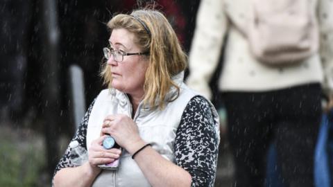 A parent waits for her children at the school