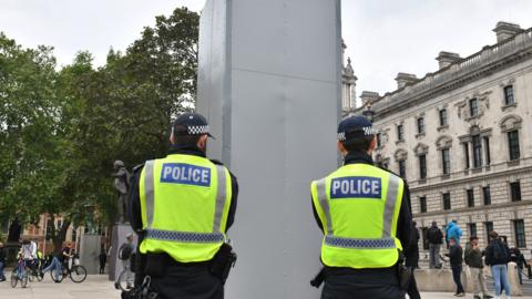 Police officers stand beside the now encased Churchill statue on Parliament Square
