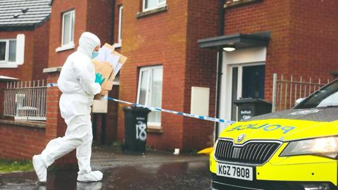 Forensics officers at an address in St Bernadette's Avenue
