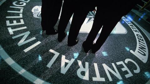 People standing over the CIA symbol at the CIA HQ in Virginia