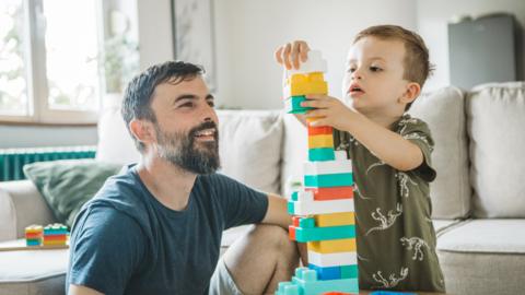 A dad and his son playing with building blocks
