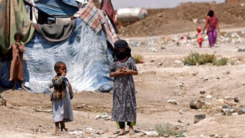 File photo showing displaced Yemeni children stand outside a make-shift shelter at a camp for internally displaced people (IDPs) on the outskirts of Sanaa on 15 April 2017