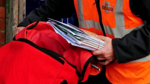 Royal Mail postal worker delivering mail